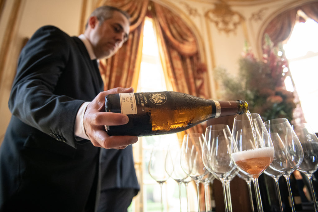 photographie d'un serveur servant un flute de champagne