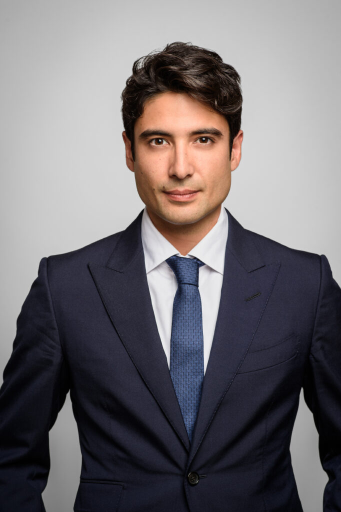 Portrait professionnel d’un homme en costume bleu marine et cravate assortie, symbolisant le sérieux, la modernité et la réussite.