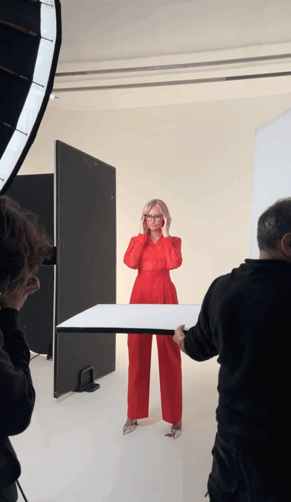 Dans les coulisses d’une séance photo corporate chez Studio Alterego : direction photo avec éclairage pro, femme en combinaison rouge face à l’objectif, photographe en action