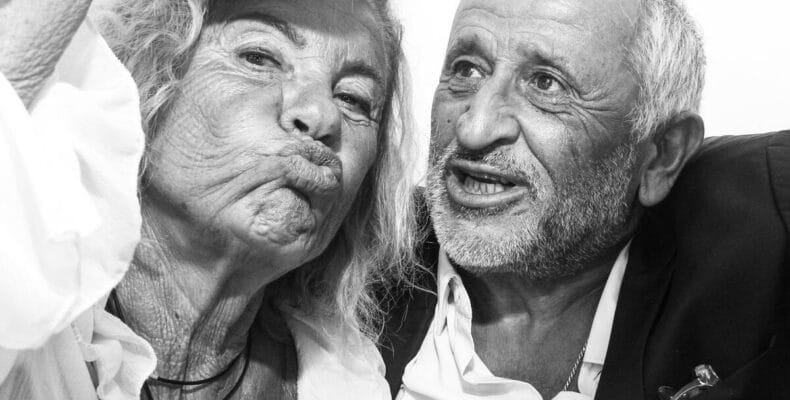 Location cabine photo : couple en noir et blanc, chapeaux à paillettes, la femme fait une moue de baiser